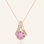 A rose gold necklace featuring a stunning 1-carat round pink moissanite centerpiece, accented with a graceful curved design adorned with sparkling cubic zirconias.