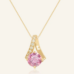 A yellow gold necklace featuring a stunning 1-carat round pink moissanite centerpiece, accented with a graceful curved design adorned with sparkling cubic zirconias.