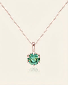 Close-up of the InfinityOne Classic Moissanite Necklace | Green Mint in rose gold, resting on a warm linen background