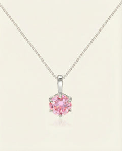 Close-up of the InfinityOne Classic Moissanite Necklace | Pink in silver, resting on a warm linen background
