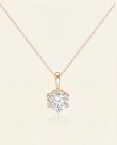 Close-up of the InfinityOne Classic Moissanite Necklace in rose gold, resting on a warm linen background