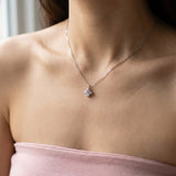 Angled lifestyle shot of the Giverny-inspired clover necklace with sparkling pink, lilac, and mint moissanite.