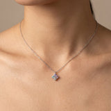 Model wearing the Tale of Two Clovers necklace in silver, showcasing the pastel moissanite side against the skin.