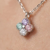 Extreme macro shot of the Tale of Two Clovers necklace, highlighting the hand-set pastel moissanite stones and rhodium-plated silver beads.