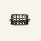 A black gold abacus ring featuring a rectangular frame with golden beads and yellow citrine stones, designed to mimic a traditional abacus, adding a playful and unique touch to your jewelry collection.