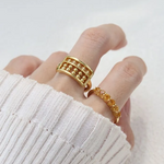 A model wearing the yellow gold abacus ring featuring a rectangular frame with golden beads and yellow citrine stones, designed to mimic a traditional abacus, adding a playful and unique touch to your jewelry collection.