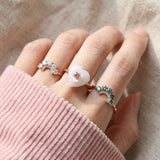 Arc Green Moissanite Ring in rose gold, worn on a model, alternate angle