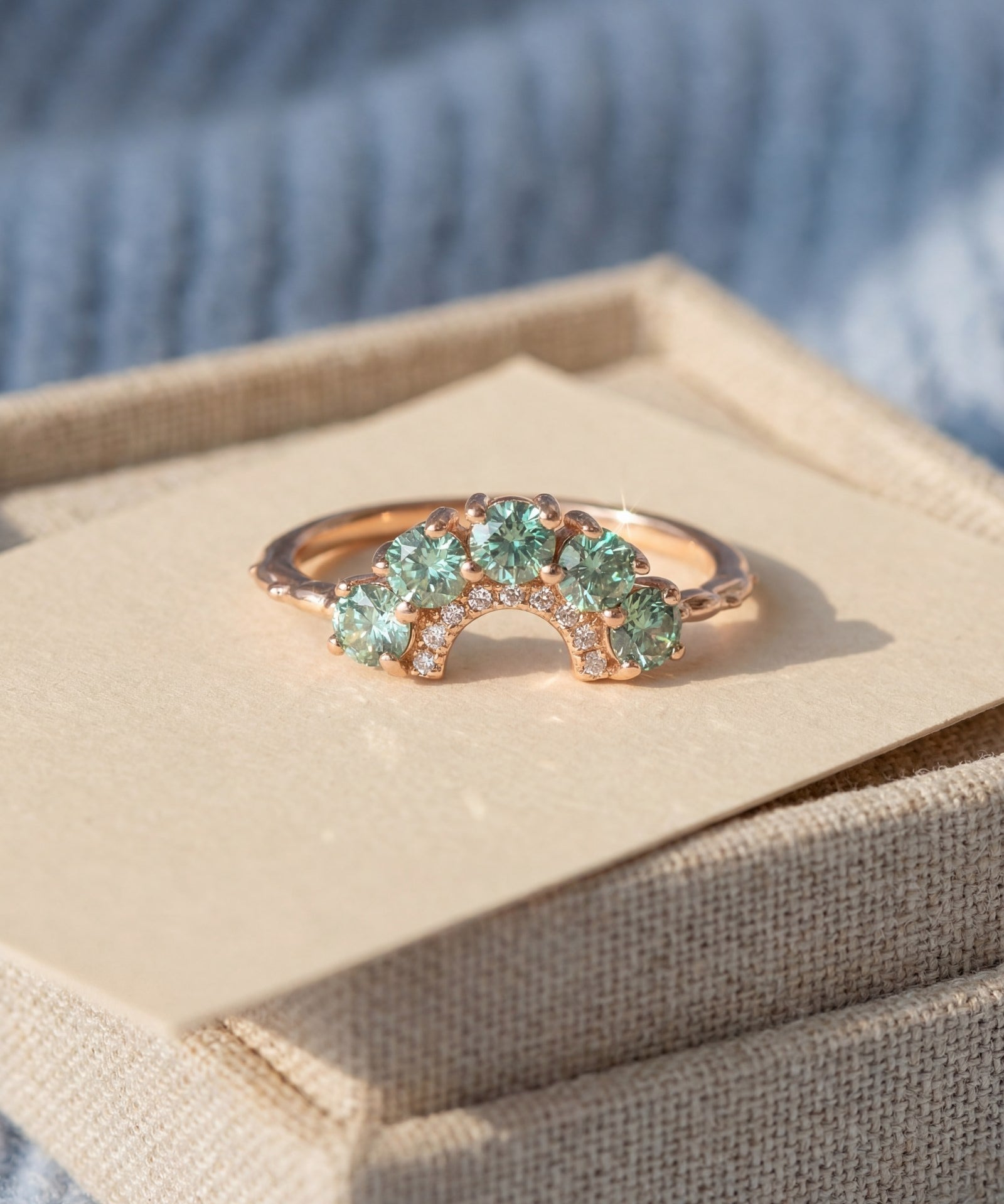 Arc Green Moissanite Ring in rose gold, laid flat on a tabletop
