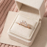 Arc White Moissanite Ring in rose gold, laid flat on a tabletop