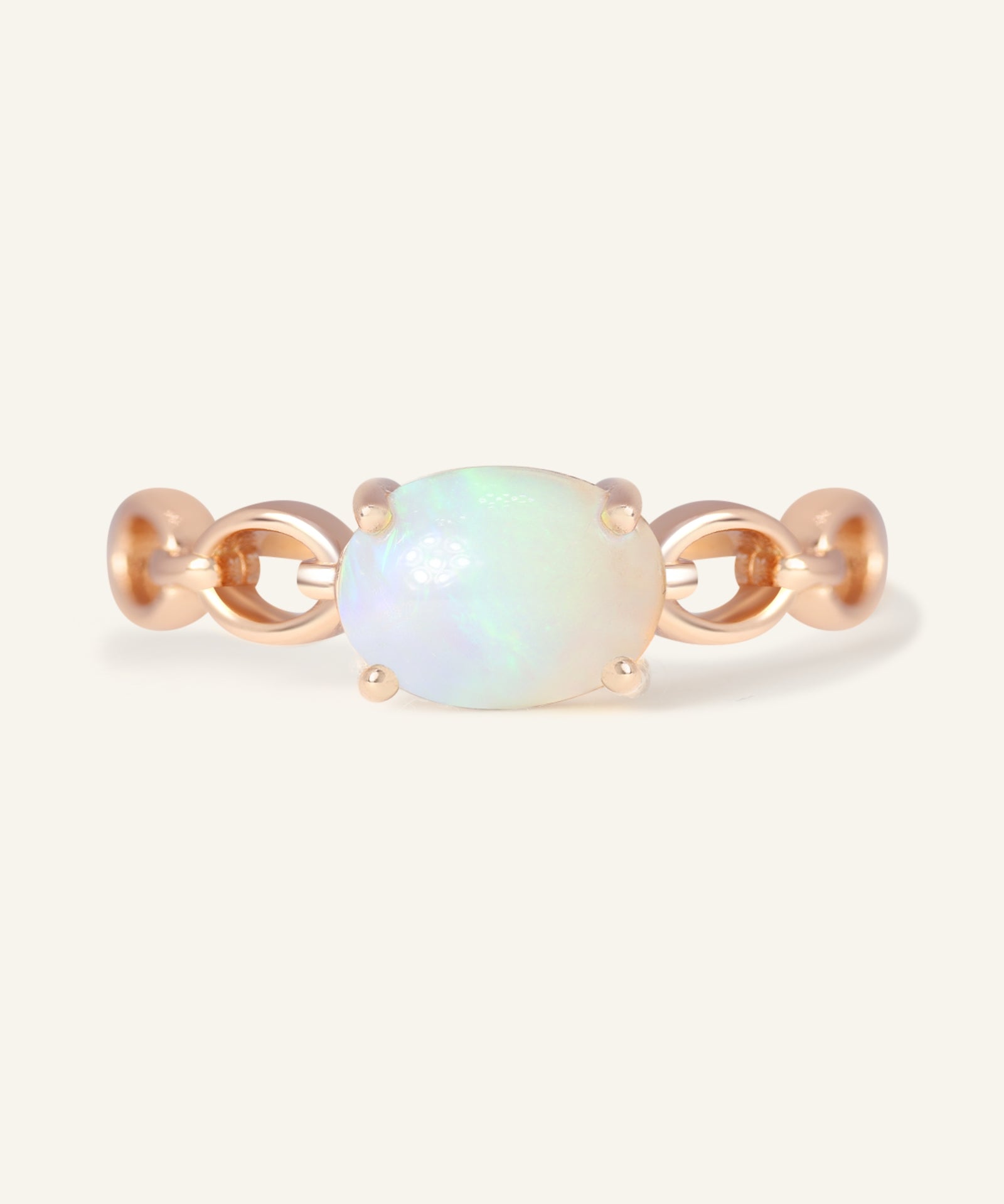 Close-up of the Astra Opal Ring in rose gold, resting on a warm linen background