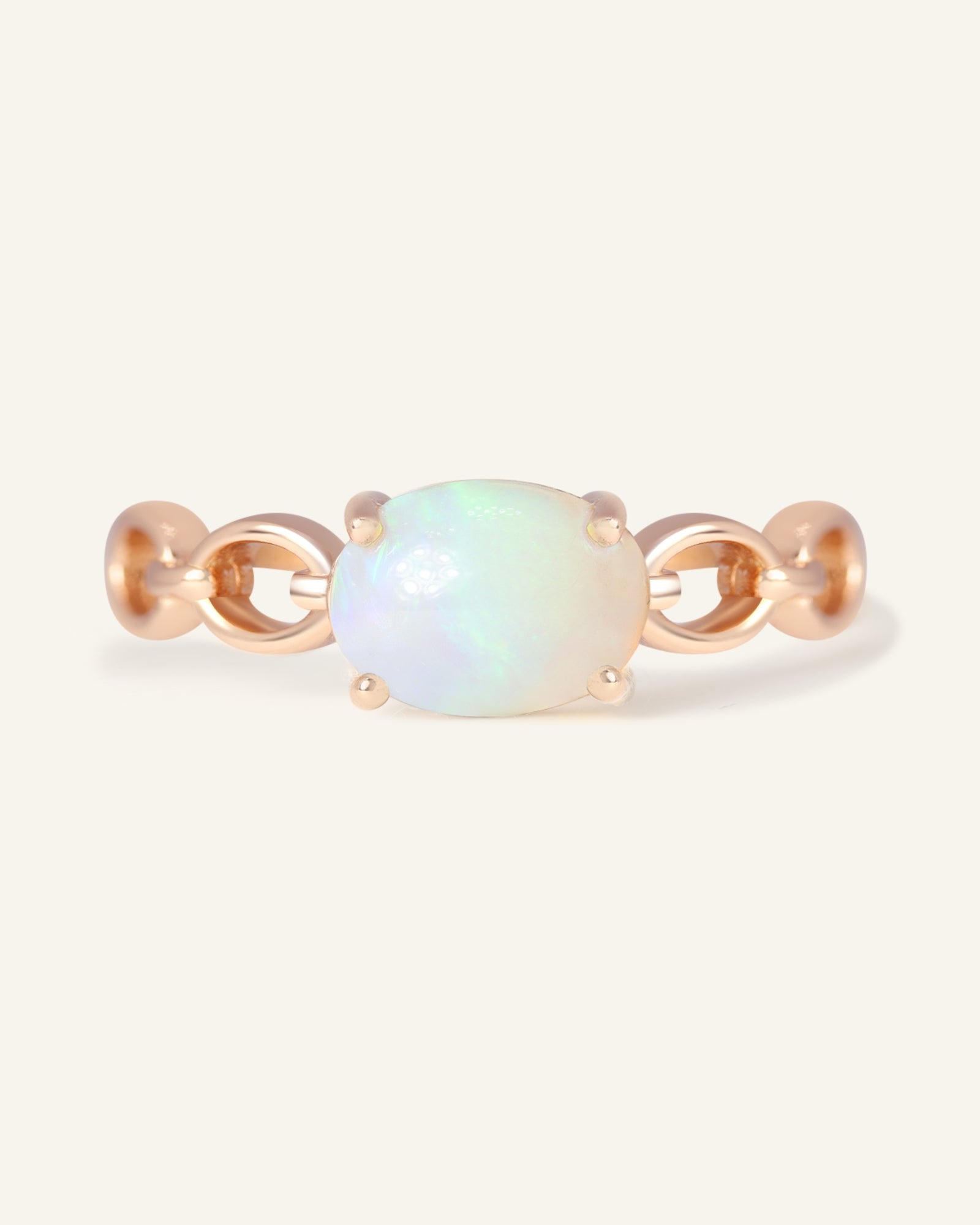 Close-up of the Astra Opal Ring in rose gold, resting on a warm linen background
