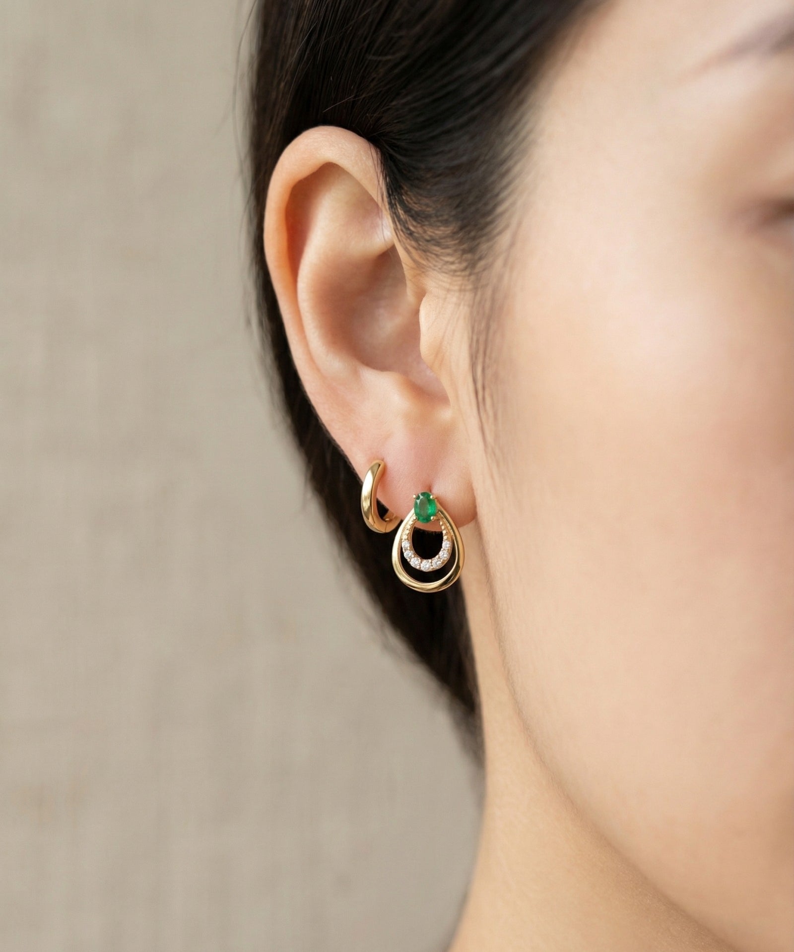 Model wearing the Aura Emerald Drop Studs in gold, showing how the teardrop design sits elegantly on the ear.