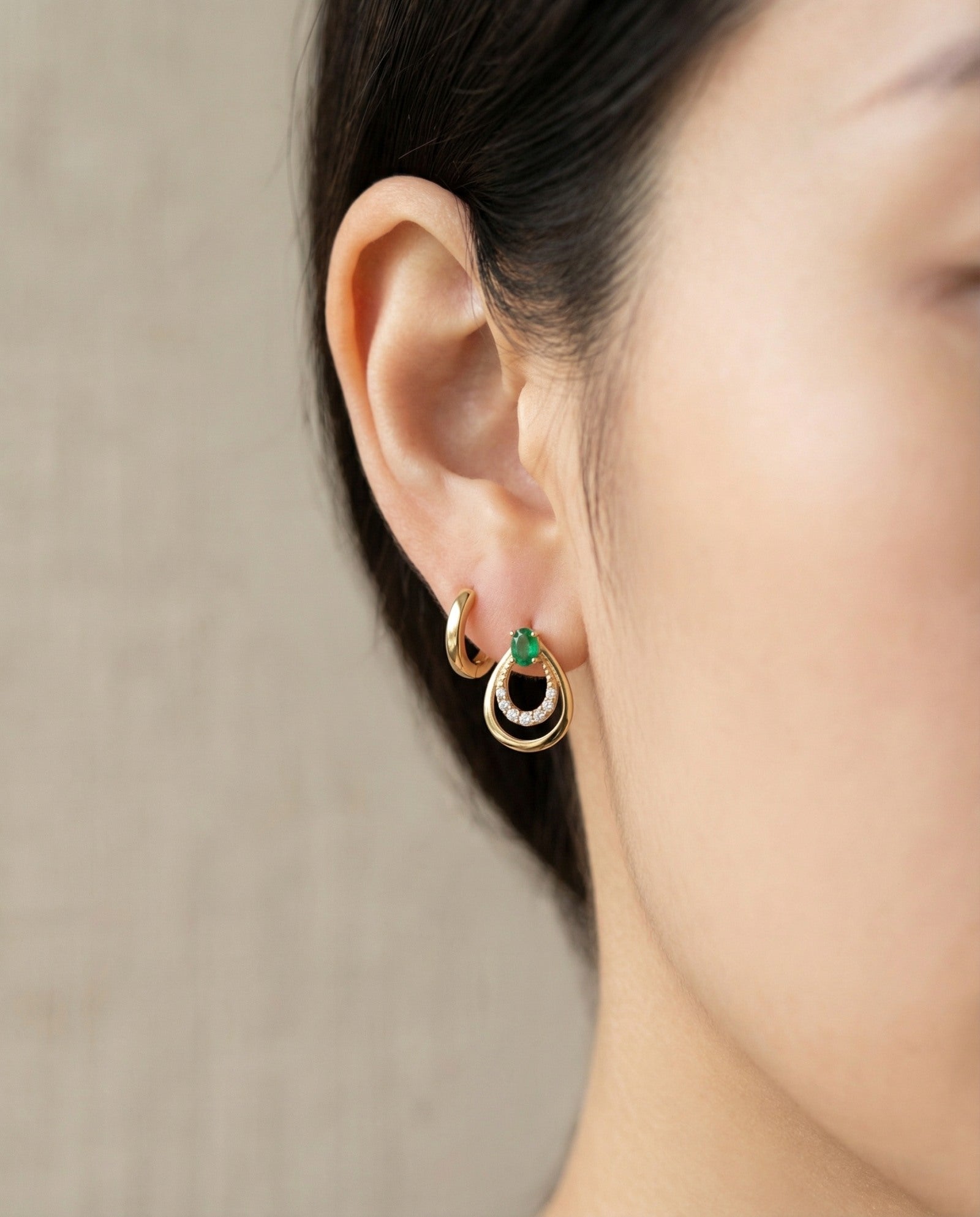 Model wearing the Aura Emerald Drop Studs in gold, showing how the teardrop design sits elegantly on the ear.