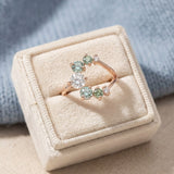 Aurora Crescent Moissanite Ring in rose gold, laid flat on a tabletop, alternate angle