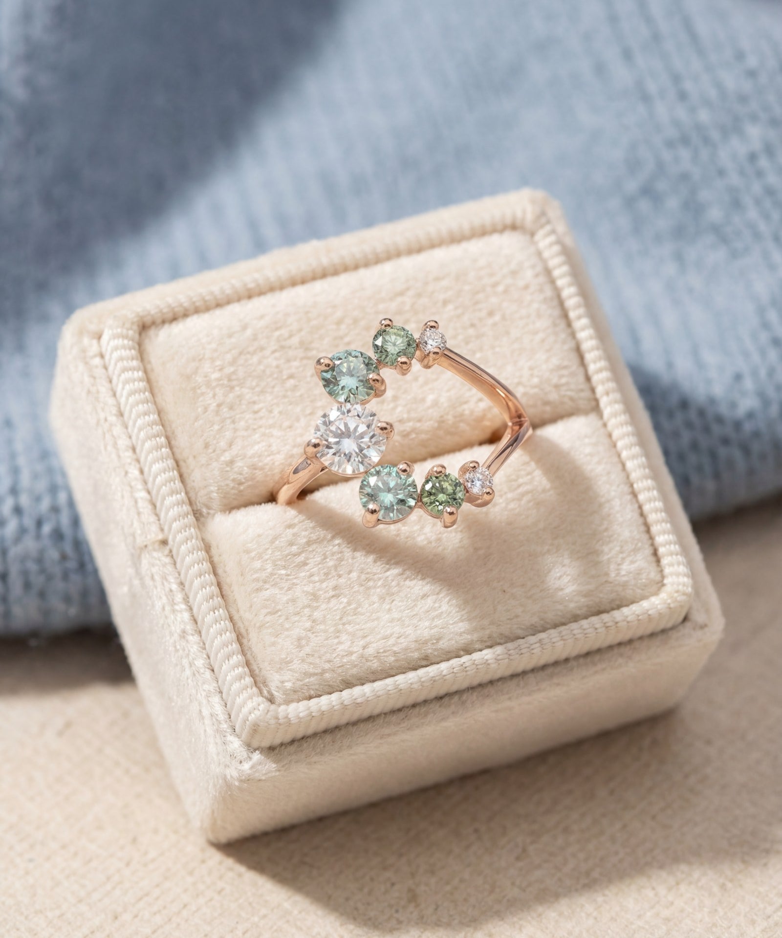 Aurora Crescent Moissanite Ring in rose gold, laid flat on a tabletop, alternate angle