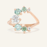 Aurora Crescent Moissanite Ring in rose gold, resting on a warm linen background