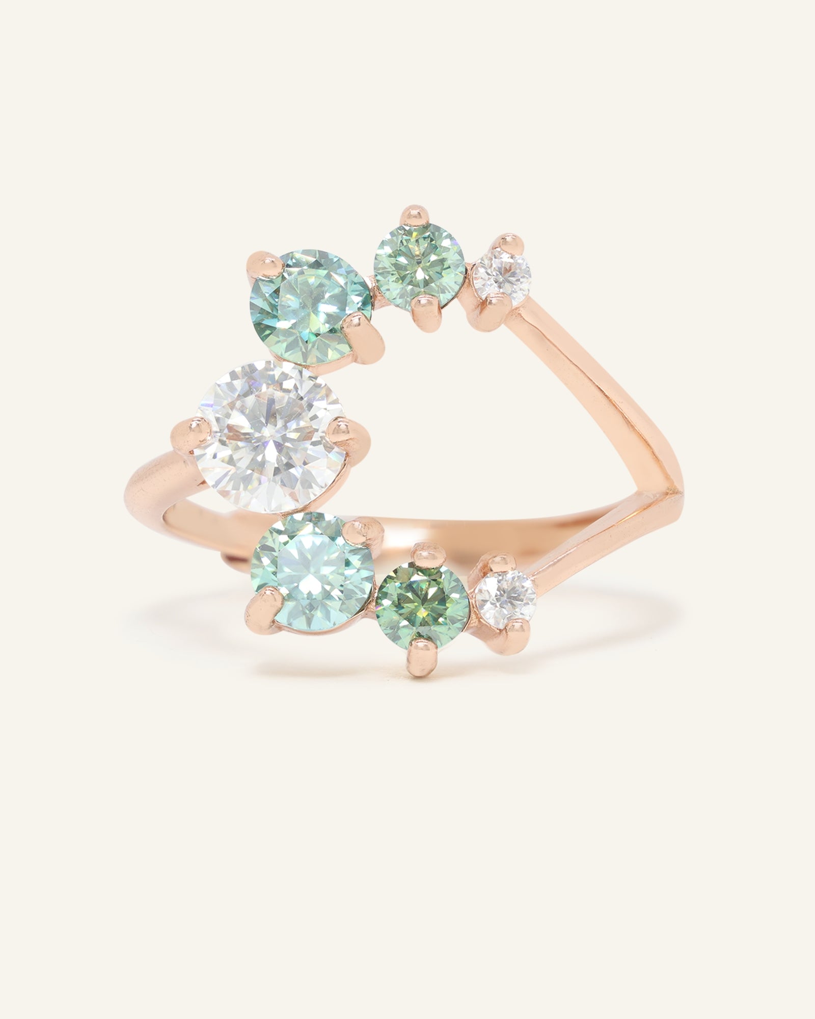 Aurora Crescent Moissanite Ring in rose gold, resting on a warm linen background