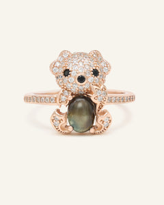 Black Sunstone Koala Bear Ring in rose gold, resting on a warm linen background
