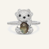 Black Sunstone Koala Bear Ring in silver, resting on a warm linen background