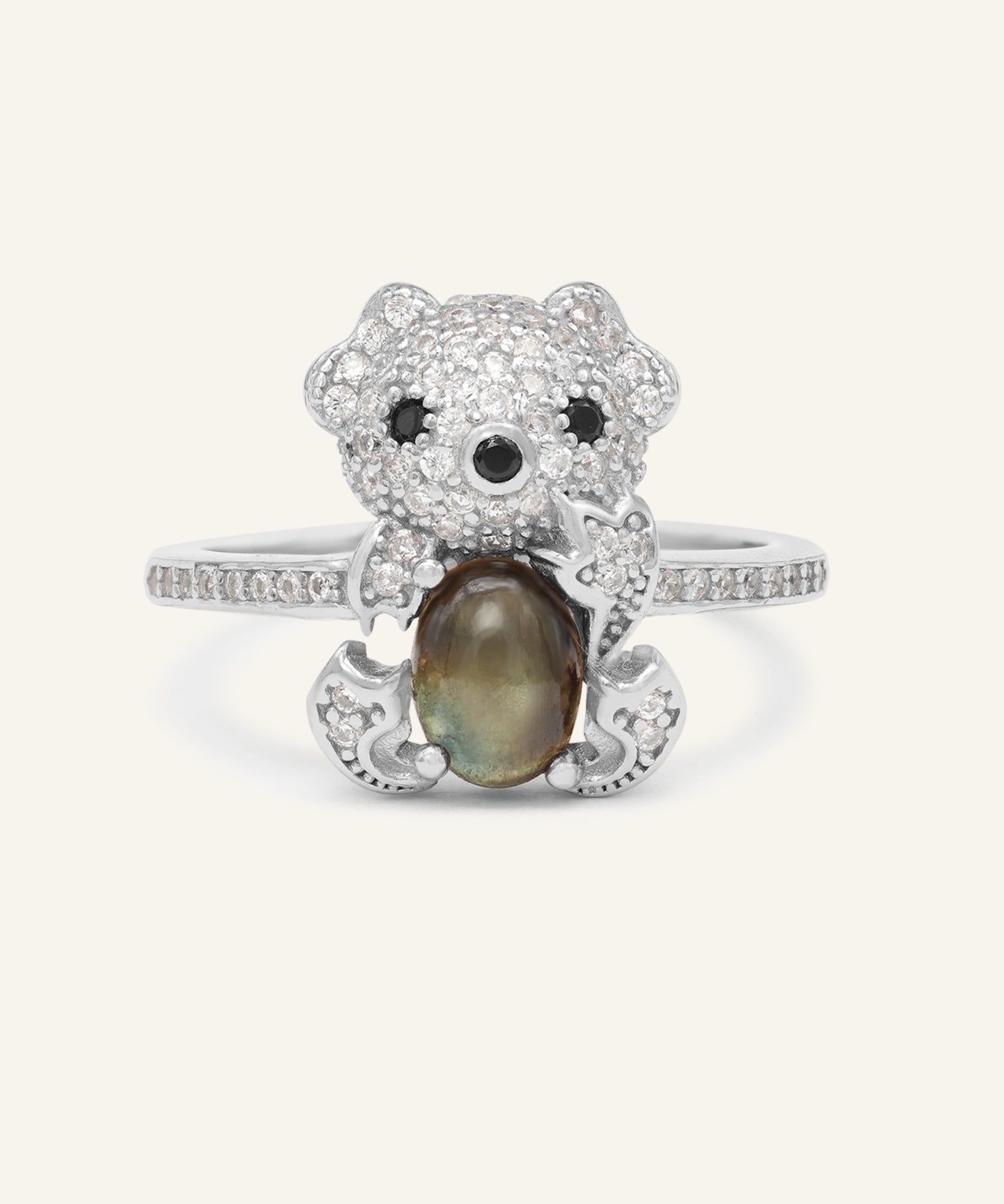 Black Sunstone Koala Bear Ring in silver, resting on a warm linen background
