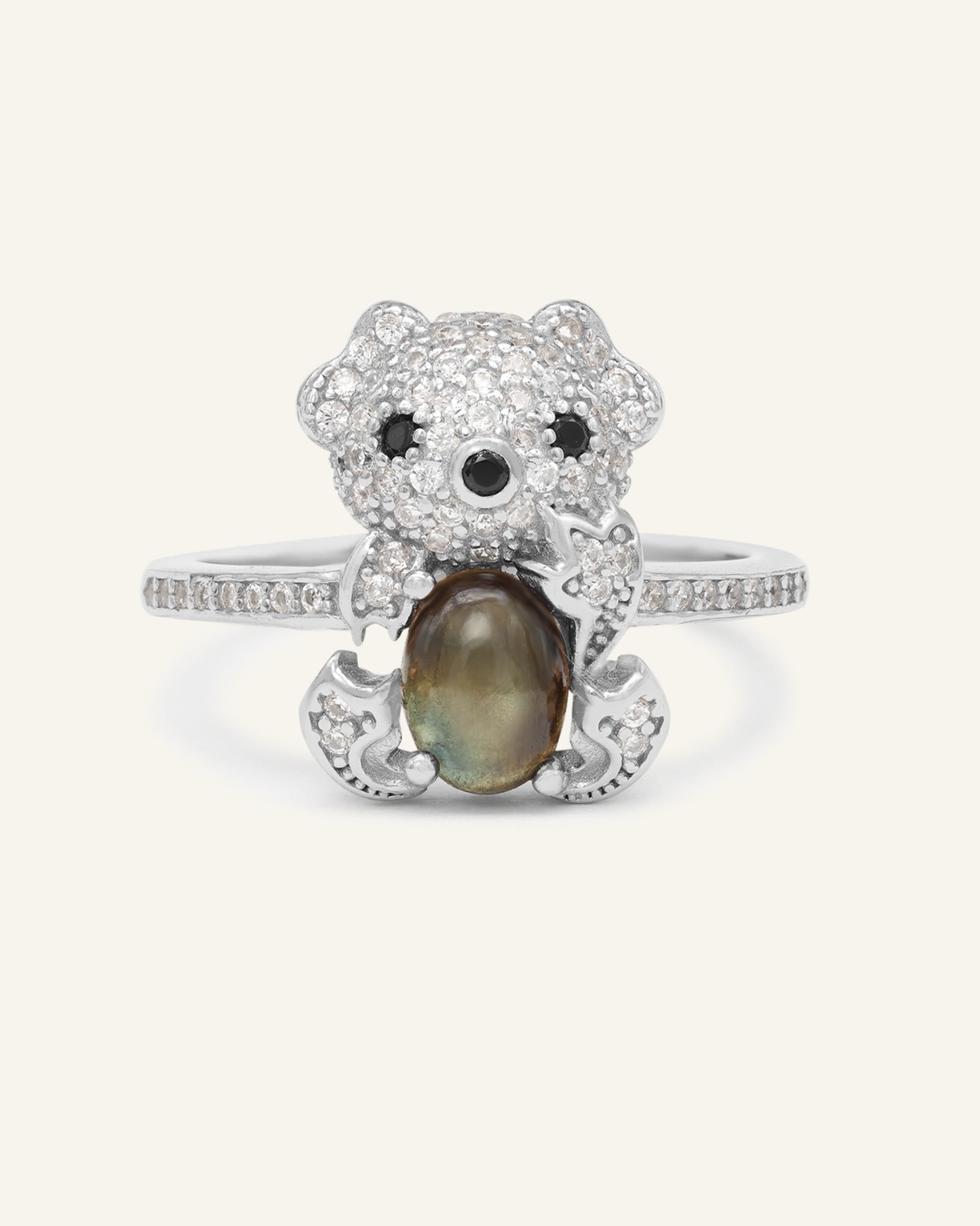 Black Sunstone Koala Bear Ring in silver, resting on a warm linen background