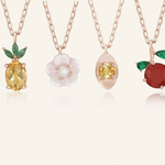 Close up of the Rose gold slider bracelet whimsical charms including a pineapple, orange, flower with pearl, and golden ingot, symbolizing blessings, wealth and joy.