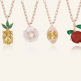 Close up of the Rose gold slider bracelet whimsical charms including a pineapple, orange, flower with pearl, and golden ingot, symbolizing blessings, wealth and joy.