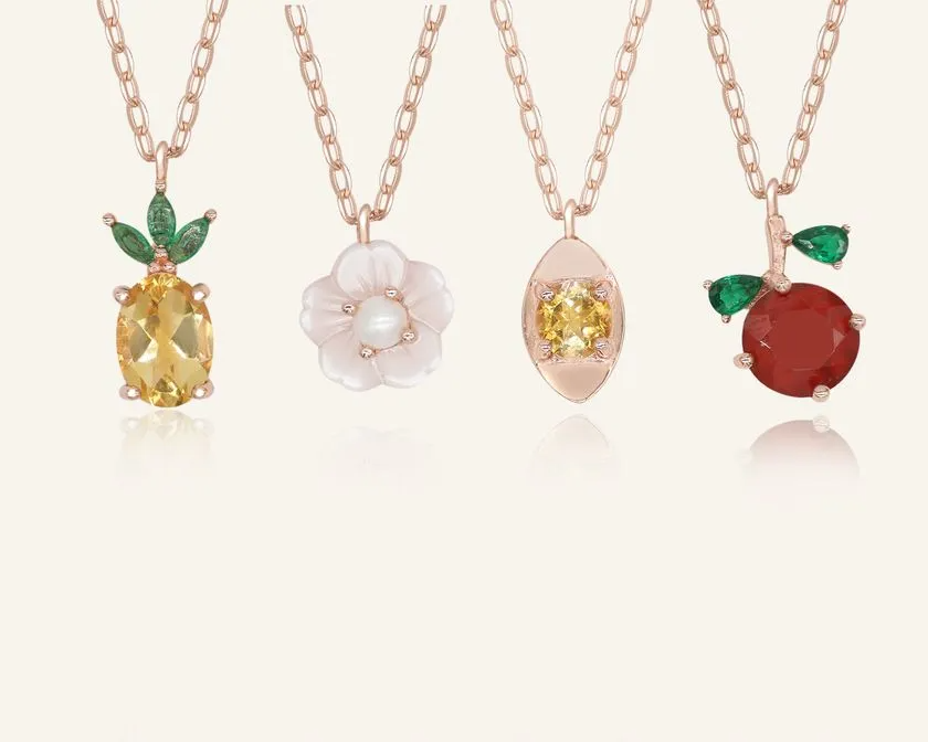 Close up of the Rose gold slider bracelet whimsical charms including a pineapple, orange, flower with pearl, and golden ingot, symbolizing blessings, wealth and joy.