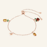 Rose gold slider bracelet featuring whimsical charms including a pineapple, orange, flower with pearl, and golden ingot, symbolizing blessings, wealth and joy.