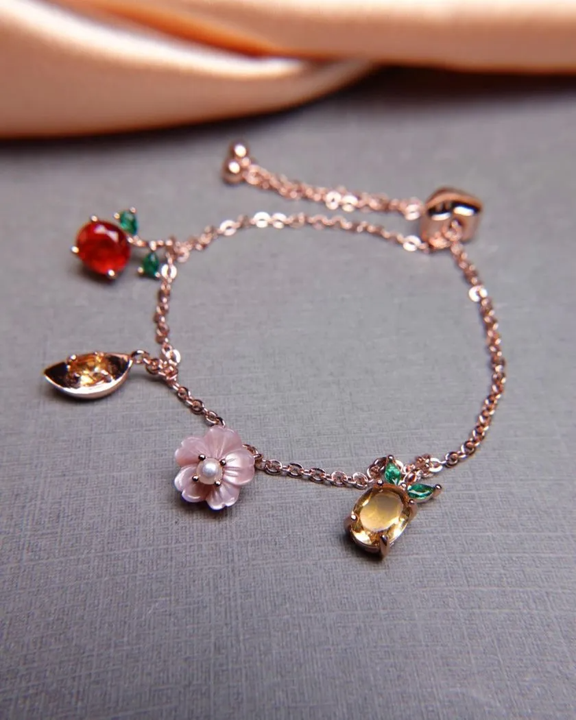 Rose gold slider bracelet featuring whimsical charms including a pineapple, orange, flower with pearl, and golden ingot, symbolizing blessings, wealth and joy.