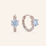 Pair of sterling silver Braided Sky Blue Moissanite Huggie Hoops featuring 0.5ct round light blue moissanite solitaire stones.