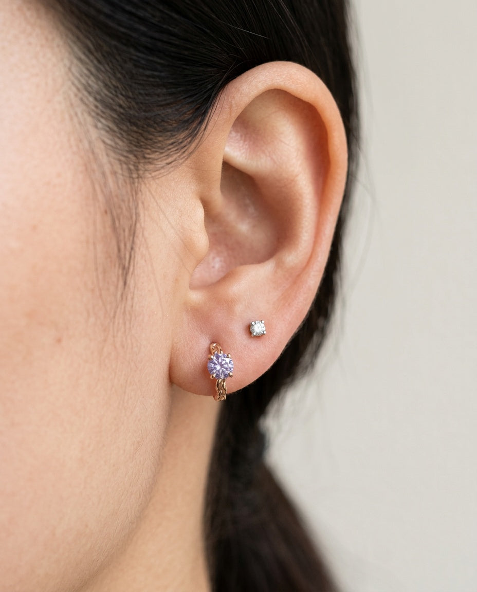 Model wearing a rose gold vermeil Braided Lavender Moissanite Huggie Hoop (1ctw) in the first lobe piercing.