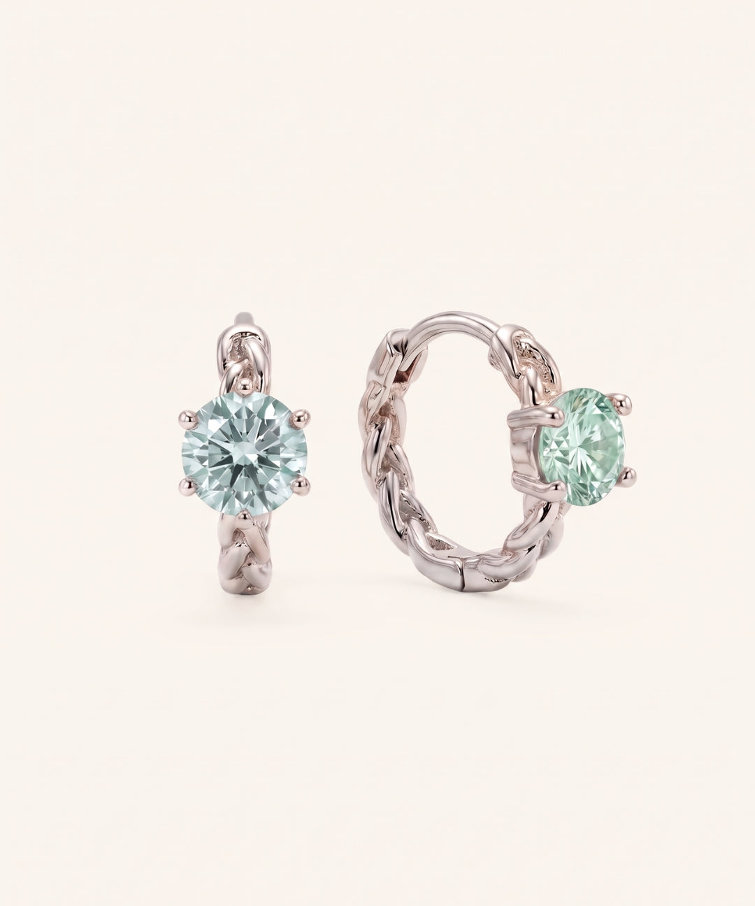 Pair of sterling silver Braided Mint Moissanite Huggie Hoops featuring 0.5ct round pastel green moissanite center stones.