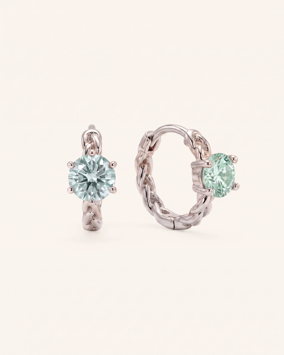 Pair of sterling silver Braided Mint Moissanite Huggie Hoops featuring 0.5ct round pastel green moissanite center stones.