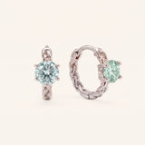 Pair of sterling silver Braided Mint Moissanite Huggie Hoops featuring 0.5ct round pastel green moissanite center stones.