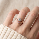 Model wearing a rose gold Braided Wishbone Lavender Moissanite Ring stacked below a large round solitaire engagement ring.