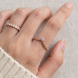 Model wearing a rose gold vermeil Braided Wishbone Lavender Moissanite Ring worn solo on index finger.