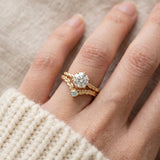 Model wearing a yellow gold Braided Wishbone Mint Moissanite Ring stacked below a one carat diamond ring.