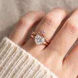 Model wearing a rose gold vermeil Braided Wishbone Pink Moissanite Ring stacked above a large heart-cut moissanite solitaire ring.