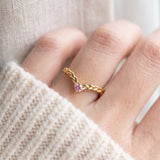 Model wearing a yellow gold vermeil Braided Wishbone Pink Moissanite Ring worn solo on index finger.