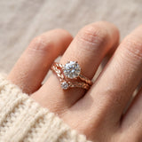 Model wearing a rose gold Braided Wishbone White Moissanite Ring stacked below a large round solitaire engagement ring.