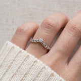 Model wearing a sterling silver Braided Wishbone White Moissanite Ring worn solo on middle finger.