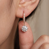 Macro shot of a model holding a 2-carat rose gold Candlelight Moissanite Solitaire Hook earring.