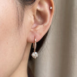 Side-profile view of a model wearing a rose gold off-white moissanite ear hook with pavé wire accents.