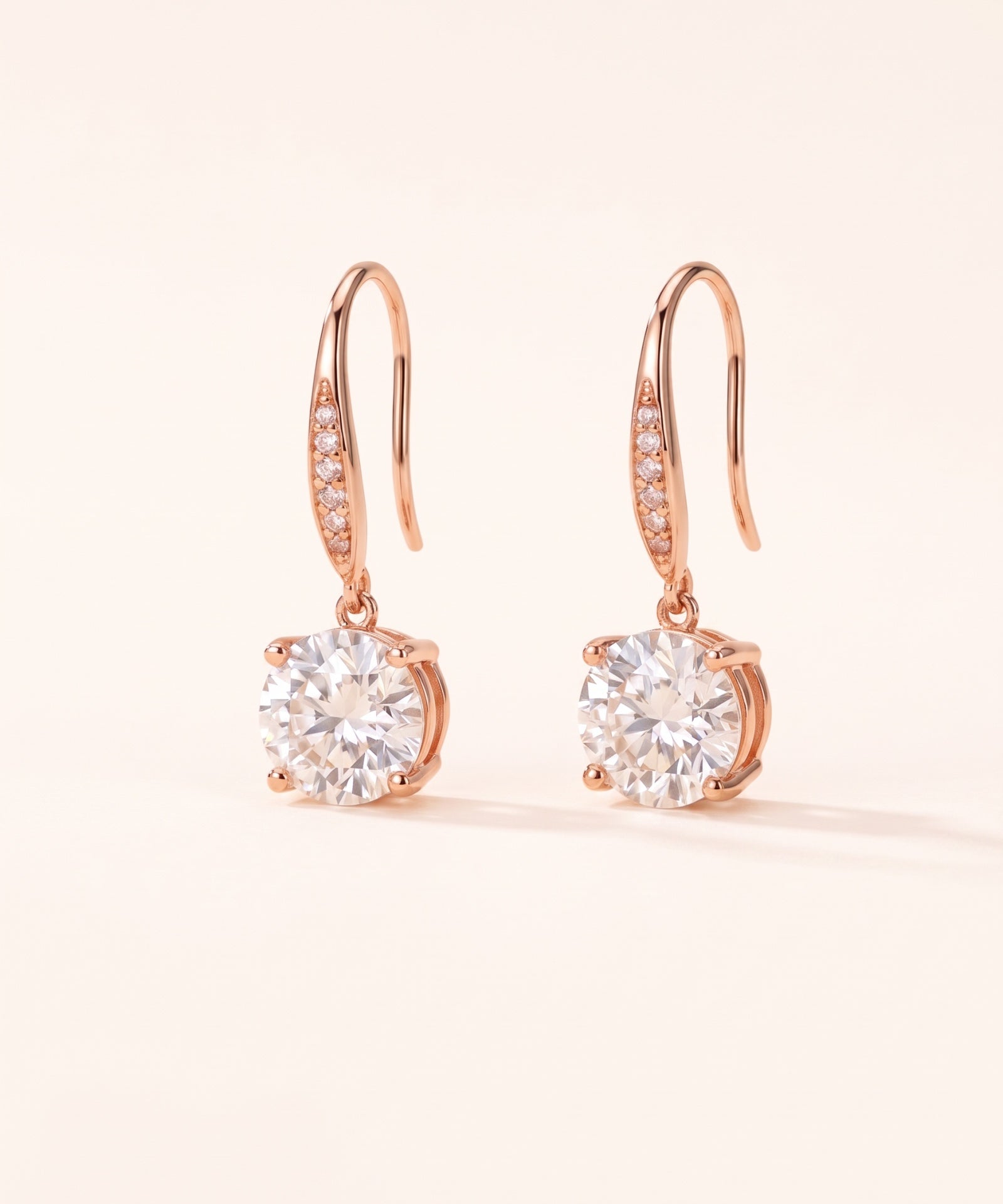 Studio pair shot of 18k rose gold Candlelight Moissanite Solitaire Hooks featuring 2-carat round off-white stones.