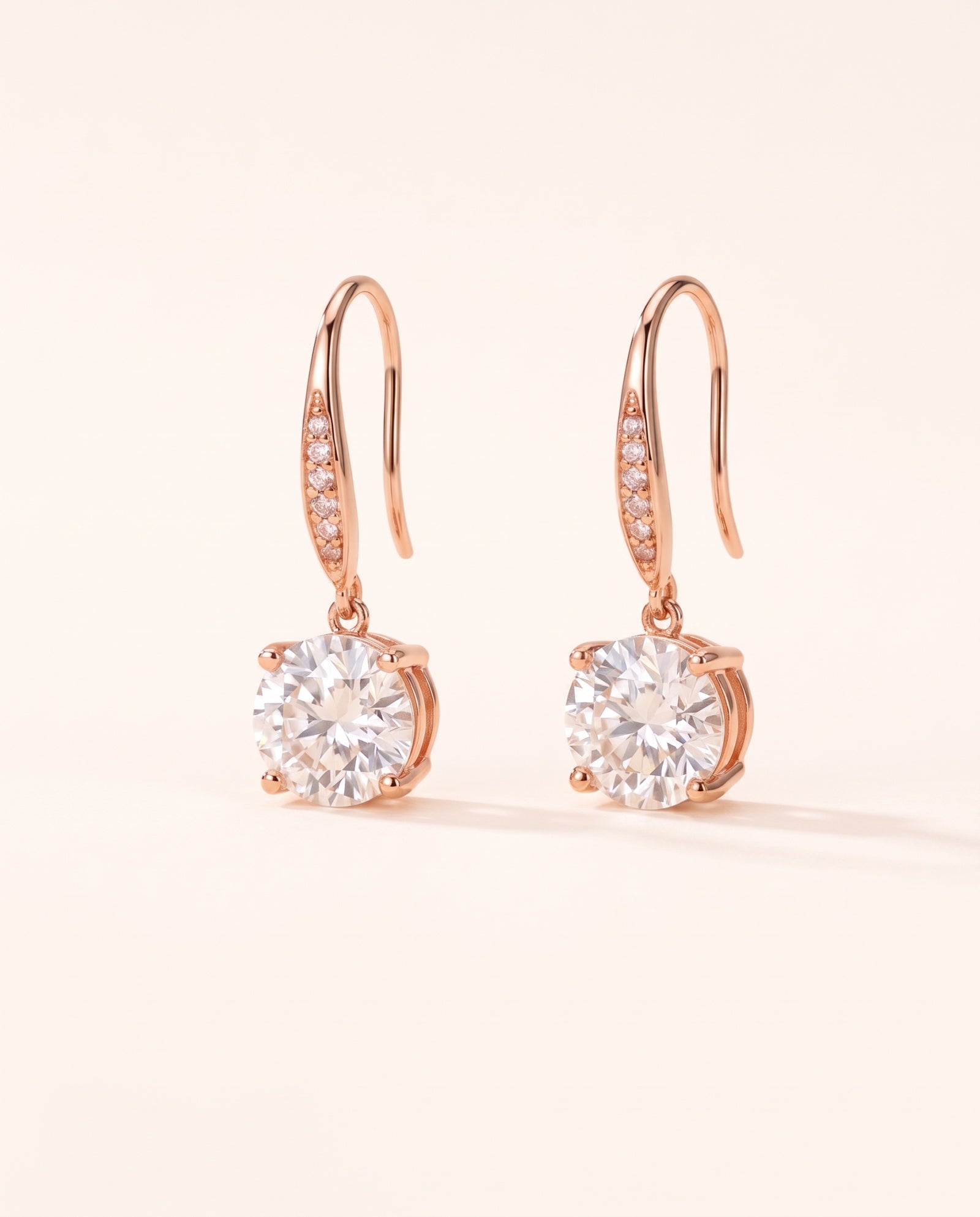 Studio pair shot of 18k rose gold Candlelight Moissanite Solitaire Hooks featuring 2-carat round off-white stones.