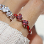 Candy Cane Ribbon Ring with heart-shaped red moissanite on finger