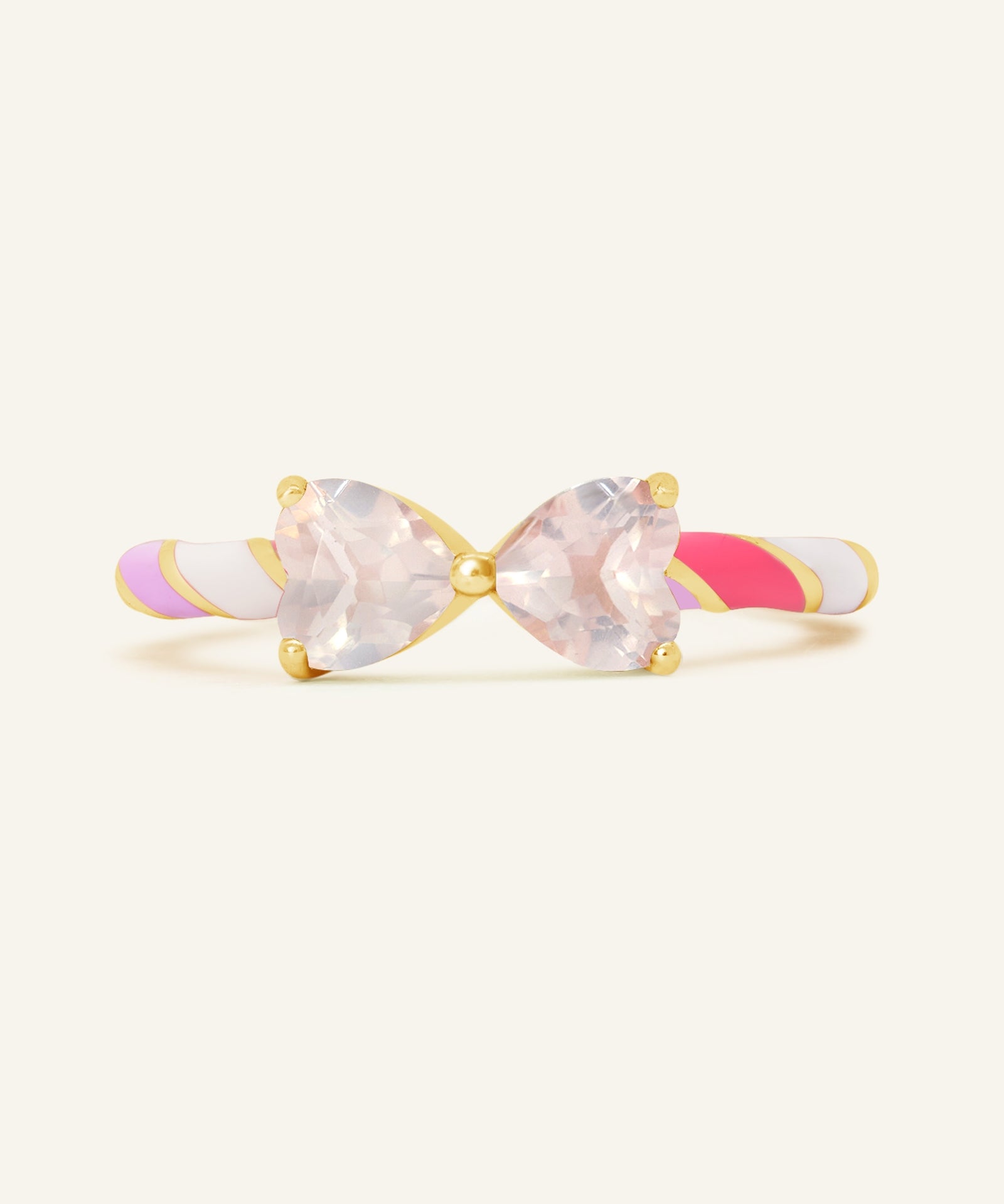 Close-up of the Candy Cane Ribbon Ring | Rose Quartz in yellow gold, resting on a warm linen background