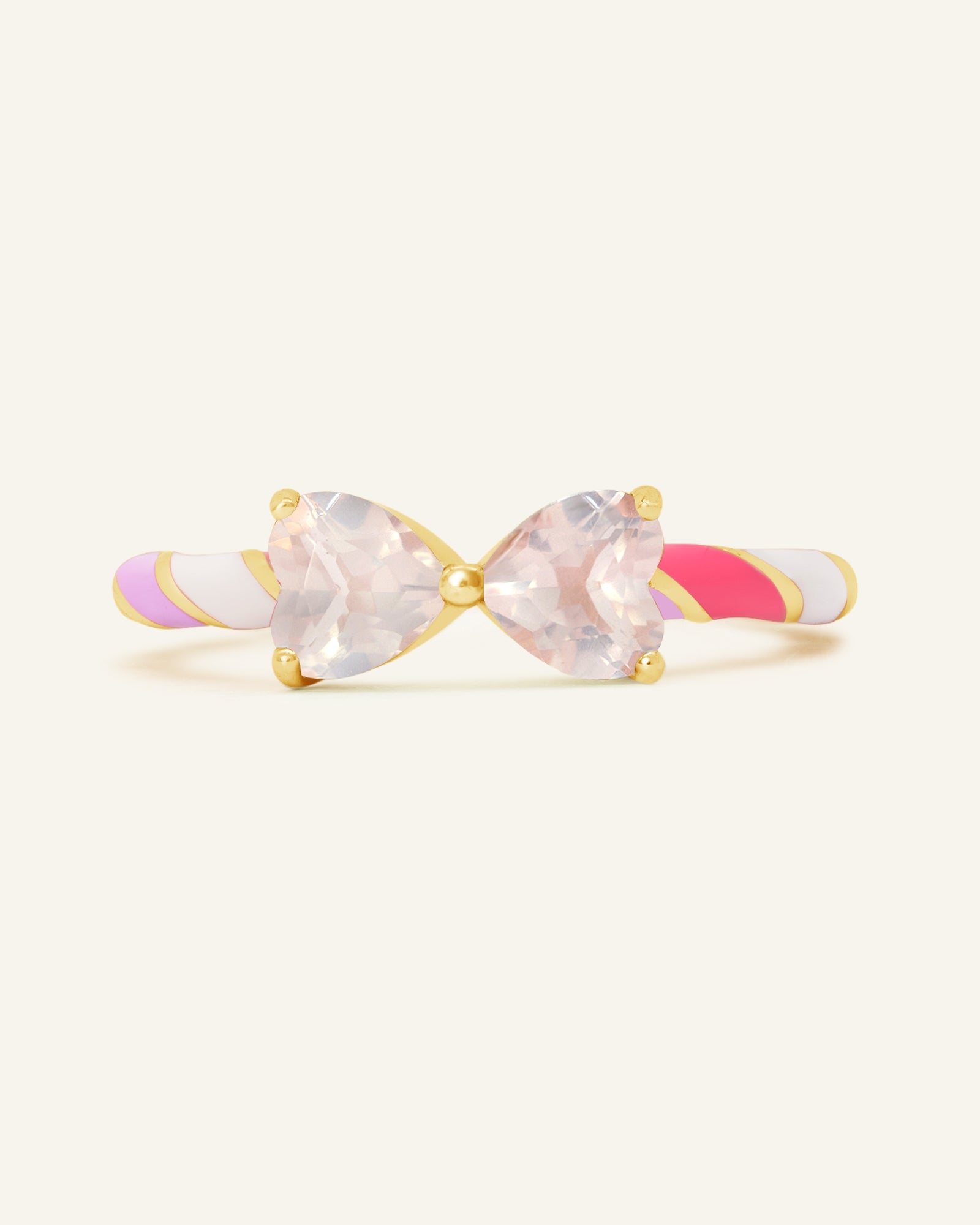 Close-up of the Candy Cane Ribbon Ring | Rose Quartz in yellow gold, resting on a warm linen background