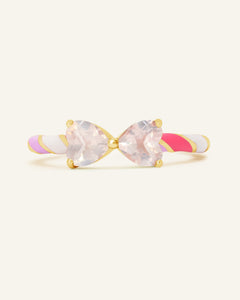 Close-up of the Candy Cane Ribbon Ring | Rose Quartz in yellow gold, resting on a warm linen background
